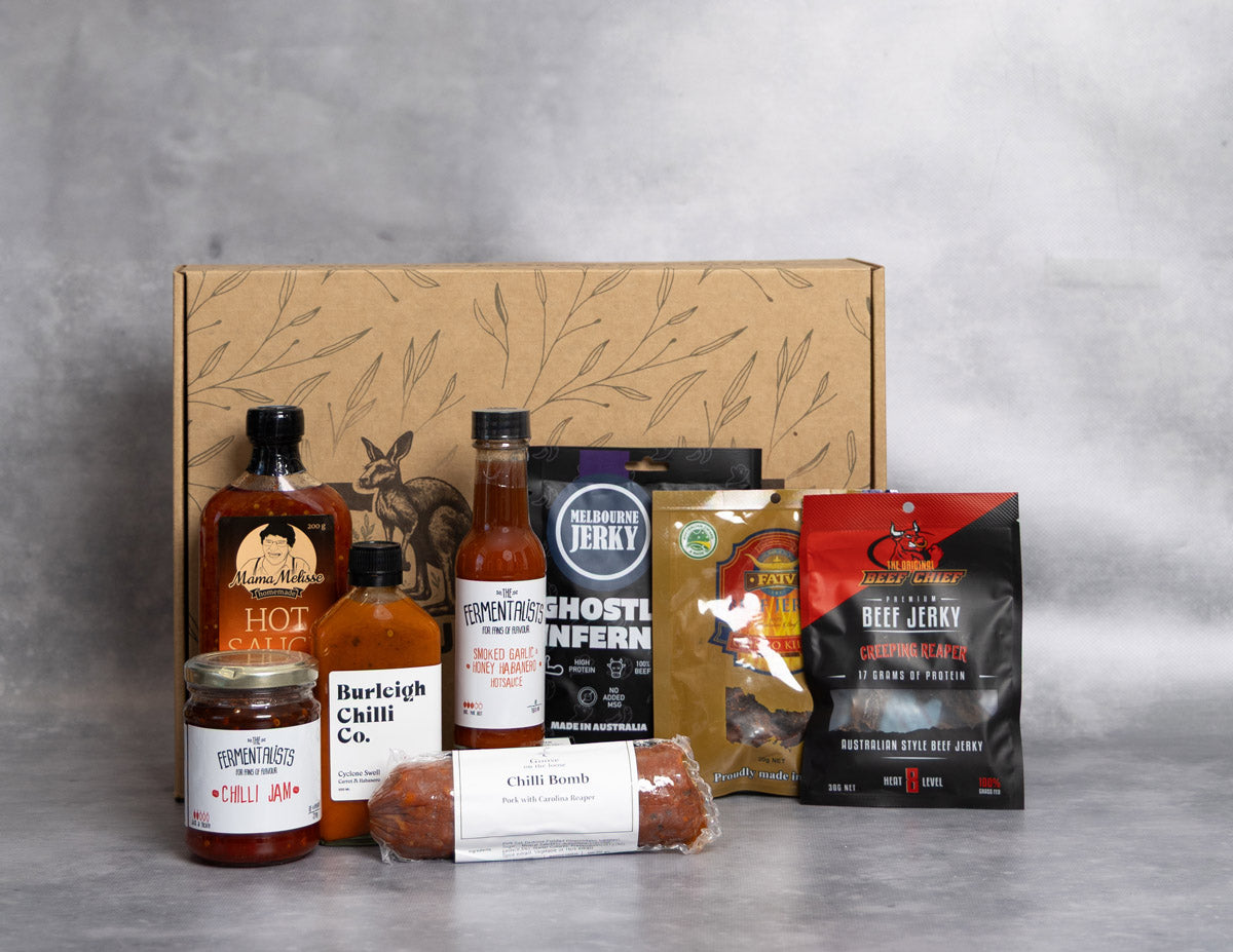 Hot Box Hamper. Collection of Jerky and Hot Sauce products with a cardboard box on a gray background